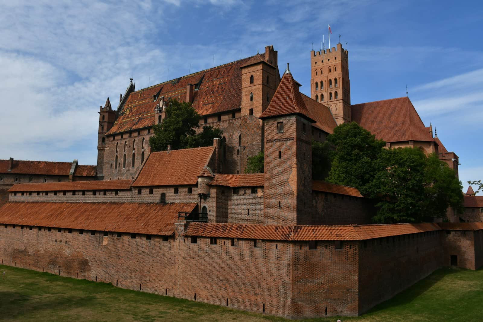 The brick walls of Malbork Castle under a blue sky